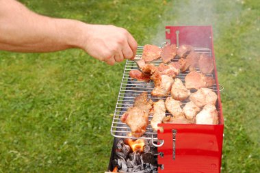 Man turning meat on a barbecue grill clipart