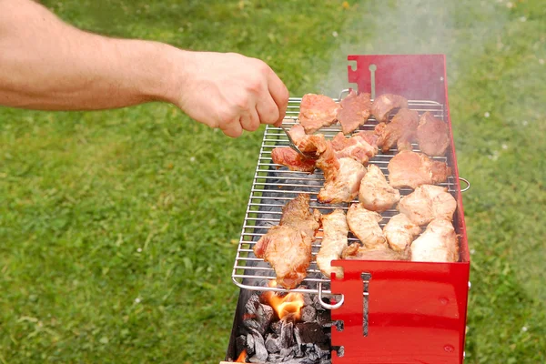 stock image Man turning meat on a barbecue grill