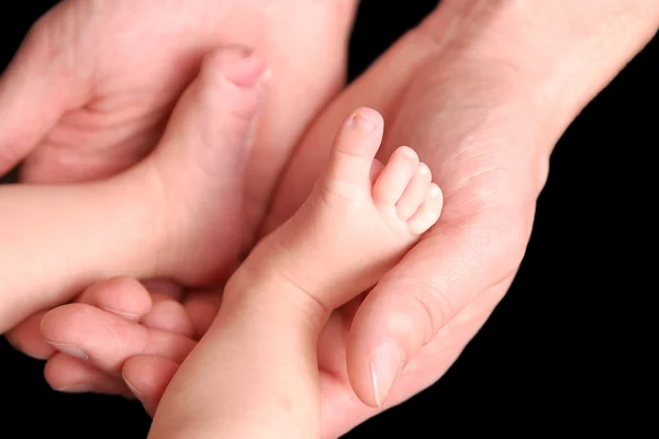 Baby foot i mors händer Stockbild
