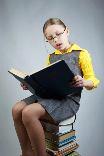 Liten flicka med böcker och glasögon — Stockfoto