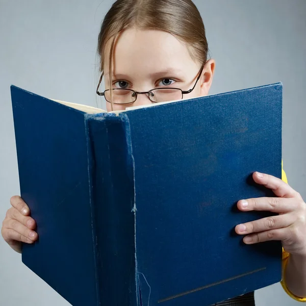 Liten flicka med böcker och glasögon — Stockfoto