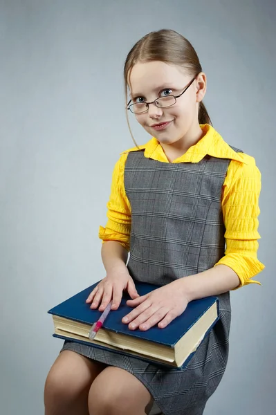 Маленькая девочка в книгах и очках — стоковое фото