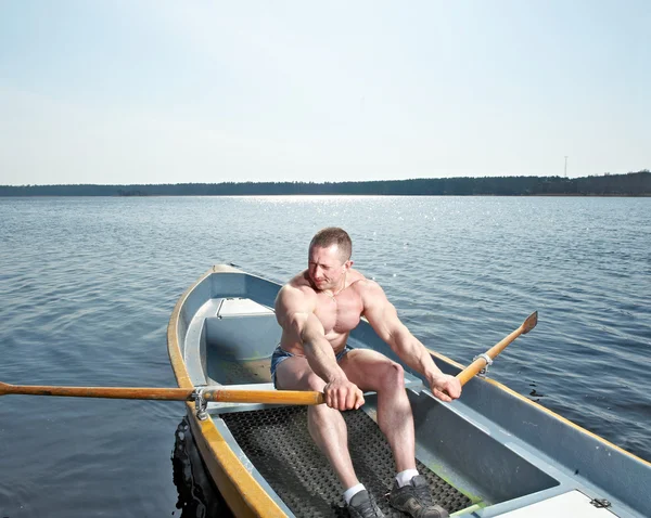 Muskulös man i båt — Stockfoto