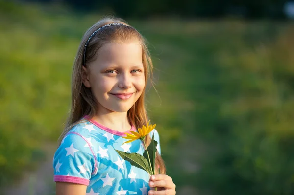 Sarı çiçek gülümseyen küçük kız — Stok fotoğraf