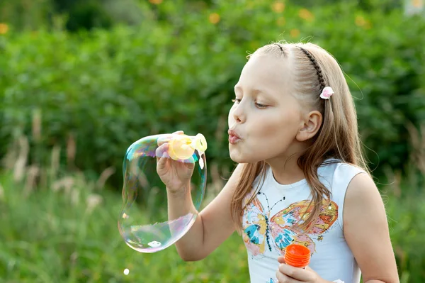 Девочка, надувающая пузыри — стоковое фото