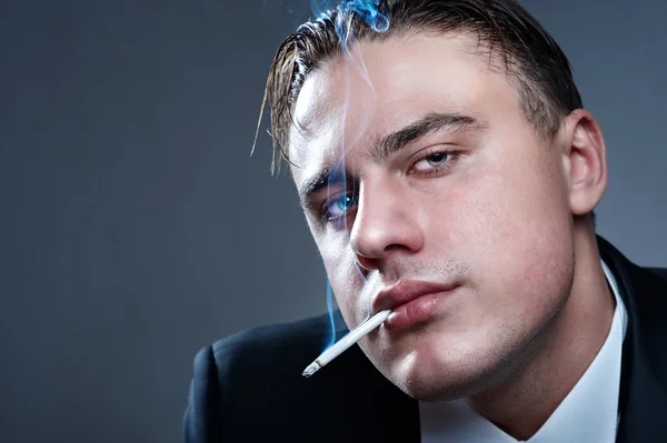 Closeup portrait of smoking handsome young man in suit — Stock Photo, Image