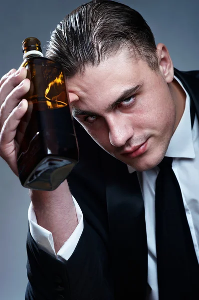 累了醉酒男子与瓶威士忌的肖像 — 图库照片