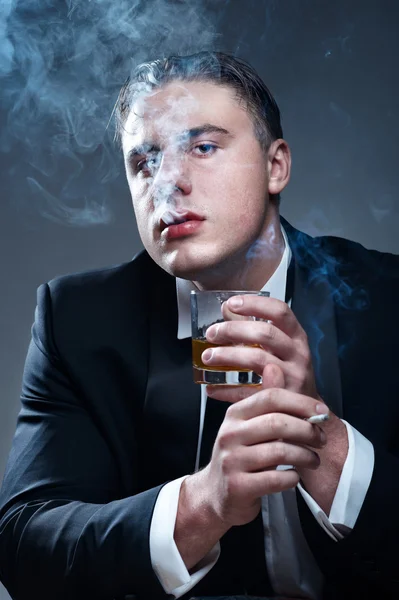 Kuřák v obleku s cigaretou a sklenici whisky — Stock fotografie