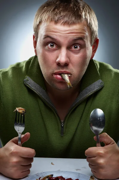 Retrato de homem faminto com peixes na boca — Fotografia de Stock