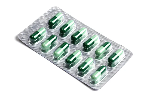 Package of green capsules isolated on white — Stock Photo, Image