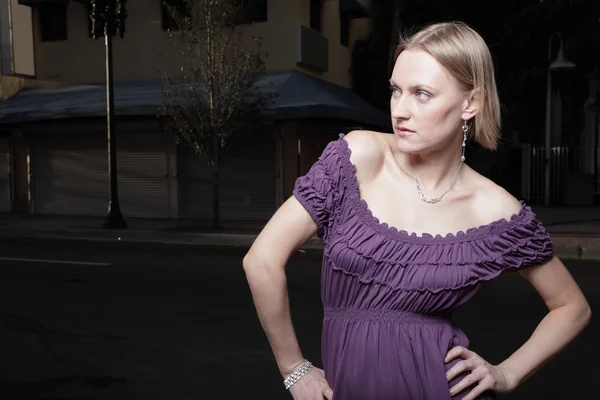 Жінка позує в фіолетовій сукні — стокове фото