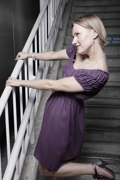 Woman posing by a staircase — Stock Photo, Image