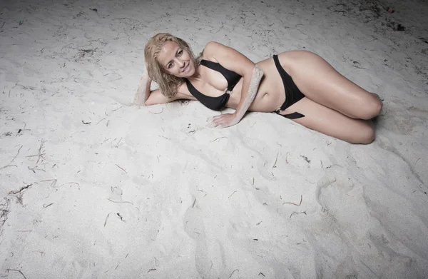 Hermosa mujer tendida en la arena — Foto de Stock