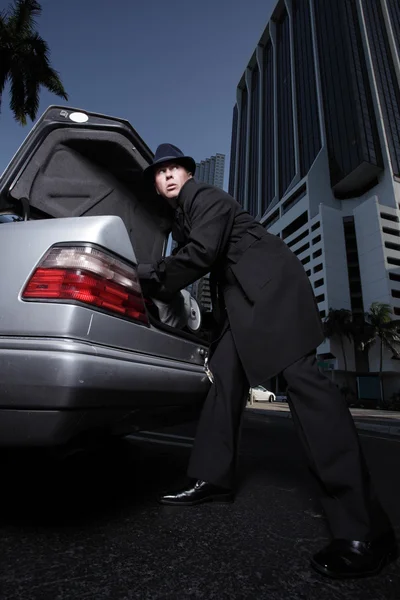 그의 트렁크에서 무언가 제거 하는 남자 — 스톡 사진
