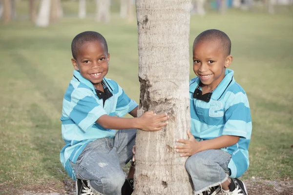 Dois meninos posando por uma árvore — Fotografia de Stock