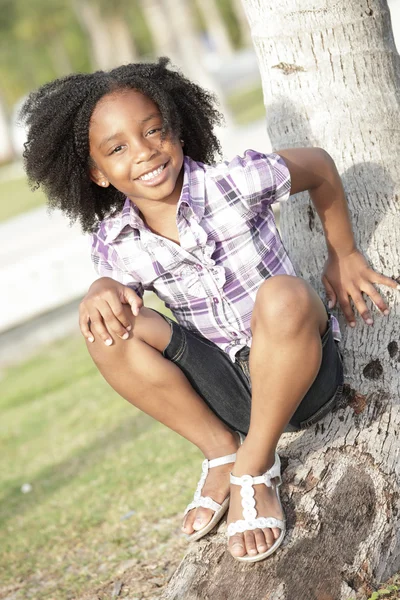 Chica joven sentada en un árbol — Foto de Stock