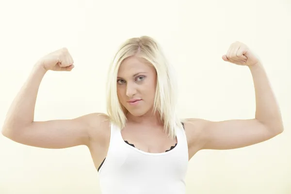 Woman flexing her arms — Stockfoto