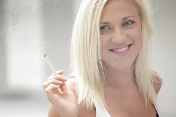 stock image Young woman smoking and smiling