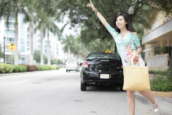 Asian woman hailing a cab — Stock Photo, Image