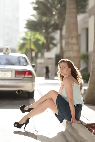 Young woman on the curb — Stock Photo, Image