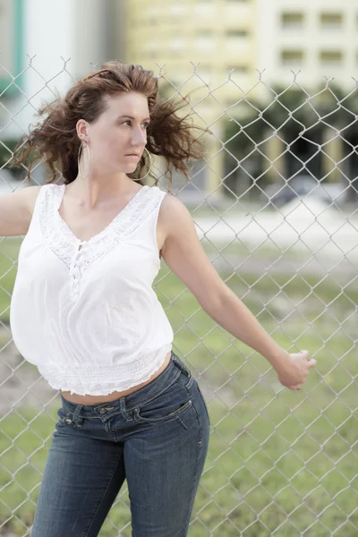 Sexy woman posing by the fence — Stock Photo, Image