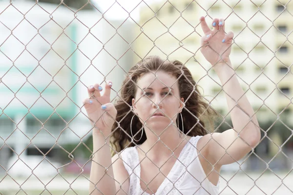 Young female model on the fence — Stock Photo, Image