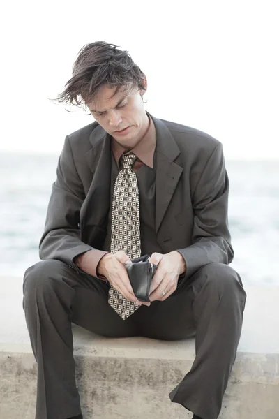 Biznesmen patrząc przez jego portfel — Zdjęcie stockowe