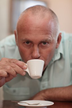 Middle-aged man drinking espresso clipart