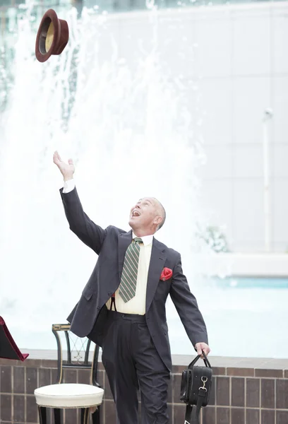 Businessman throwing his hat in the air — Stock Photo, Image