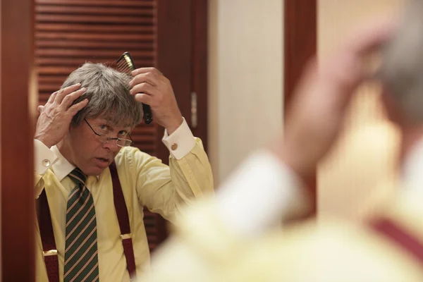 BBBusinessman adjusting his toupee — Stock Photo, Image