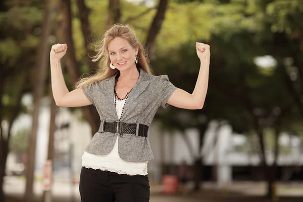 Young businesswoman flexing her arms — Stock Photo, Image