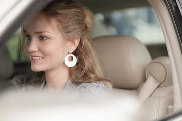 Kvinnan leende i hennes bil — Stockfoto