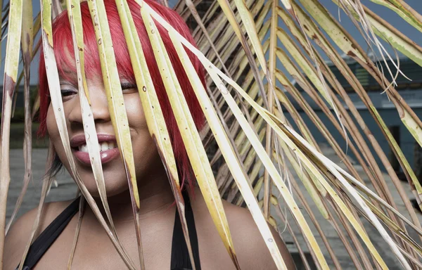 Woman and a palm frond — Stock Photo, Image