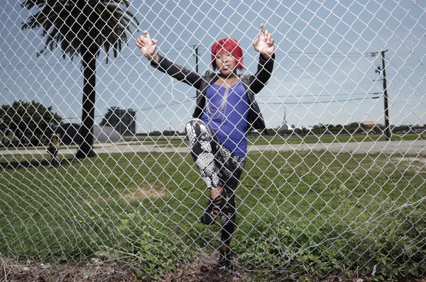 Woman climbing the fence — Stock Photo, Image
