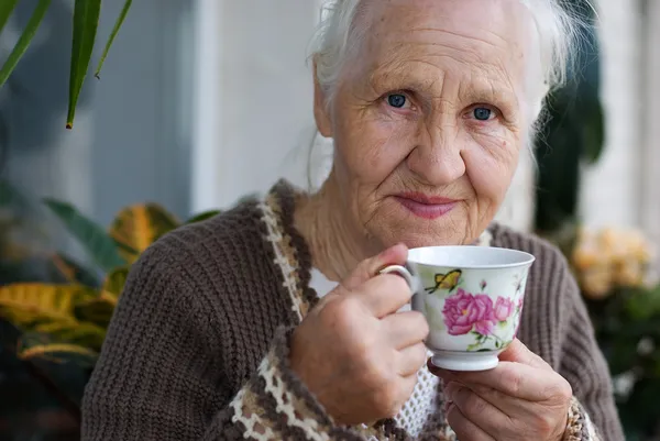Oudere vrouw met kopje thee — Stockfoto