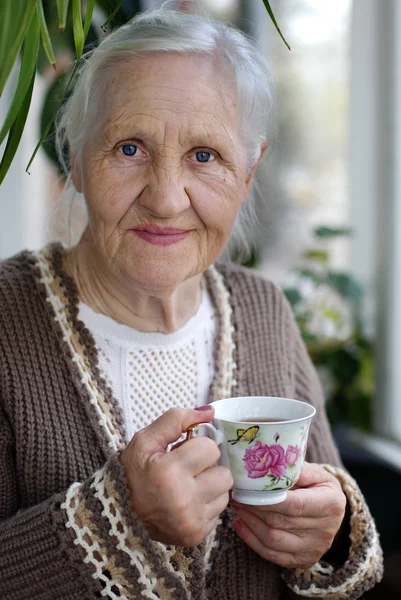 Ηλικιωμένη γυναίκα με φλιτζάνι τσάι — Φωτογραφία Αρχείου