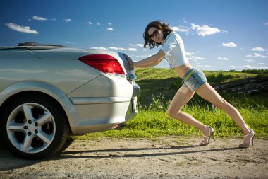 Woman is pushing broken car