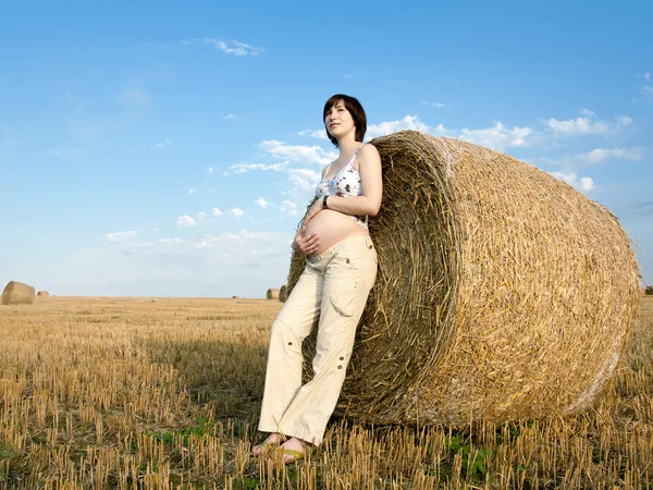Une femme enceinte reste près des balles sur le terrain — Photo