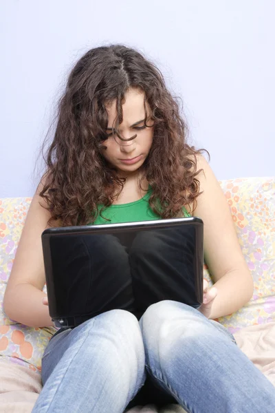 Dziewczyna w łóżku patrząc na jej laptopie — Zdjęcie stockowe