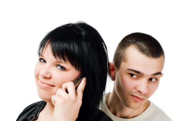 Молодая женщина с мобильным телефоном и парень подслушивает — стоковое фото