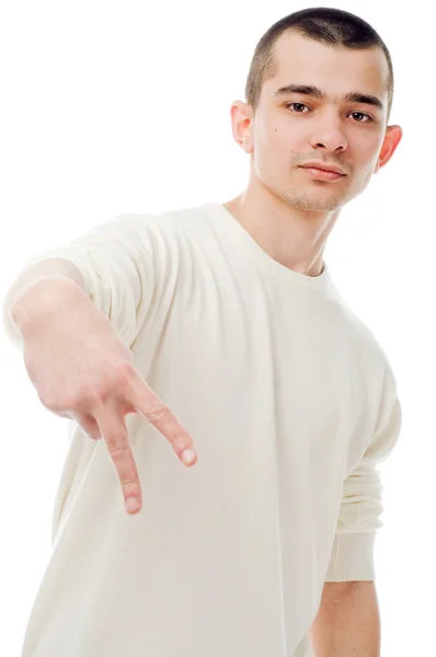 Giovane uomo mostrando segno su sfondo bianco — Foto Stock