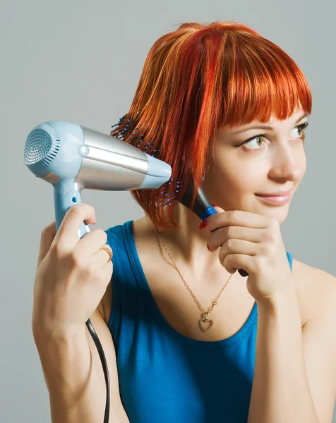 stock image Woman with hairdryer and a hairbrush