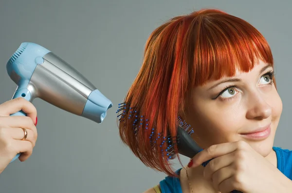 stock image Woman with hairdryer and a hairbrush