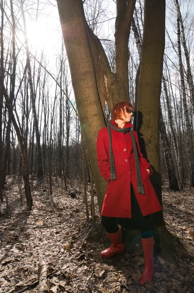 Beautiful girl wearing red coat and sunglasses — Stock Photo, Image