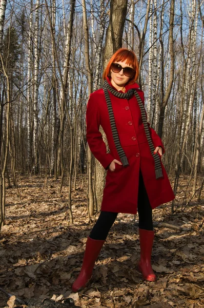 Όμορφη κοπέλα φορώντας κόκκινο παλτό και γυαλιά ηλίου — Φωτογραφία Αρχείου
