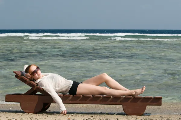 Hermosa mujer roja relajándose junto al océano — Foto de Stock