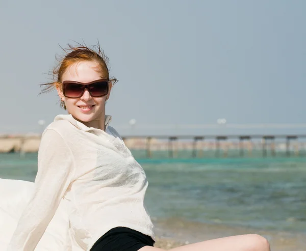 Hermosa mujer roja relajándose junto al océano —  Fotos de Stock