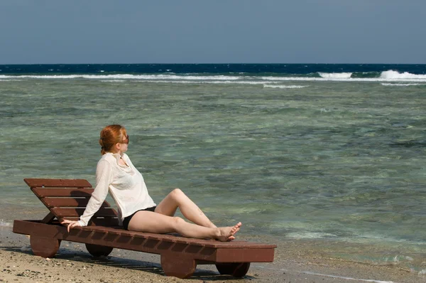 Beautiful red woman relaxing by the ocean — Stock Photo, Image
