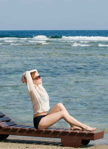 Mulher vermelha bonita relaxando junto ao oceano — Fotografia de Stock