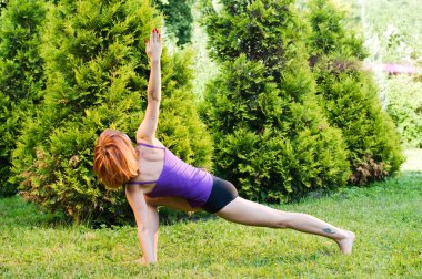 güzel bir kırmızı kadın fitness ya da yoga exerci yapıyor